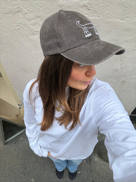 Girl wearing a gray cap of BERT Coffee & Matcha. Merchandise. 